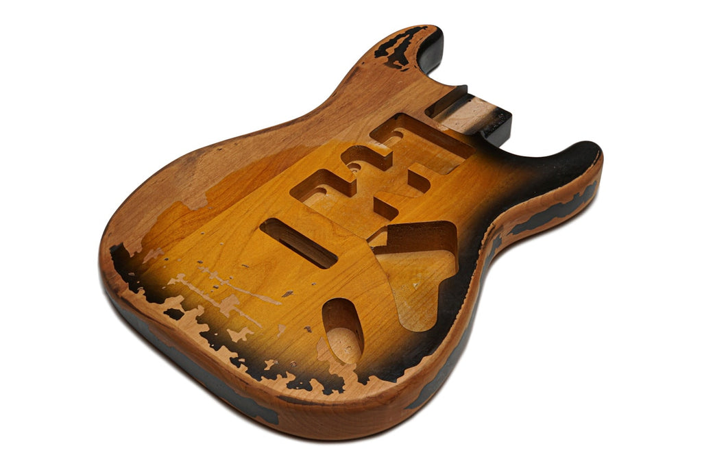 A relic finished guitar body with a 2 tone sunburst pattern and routed pickup cavities.