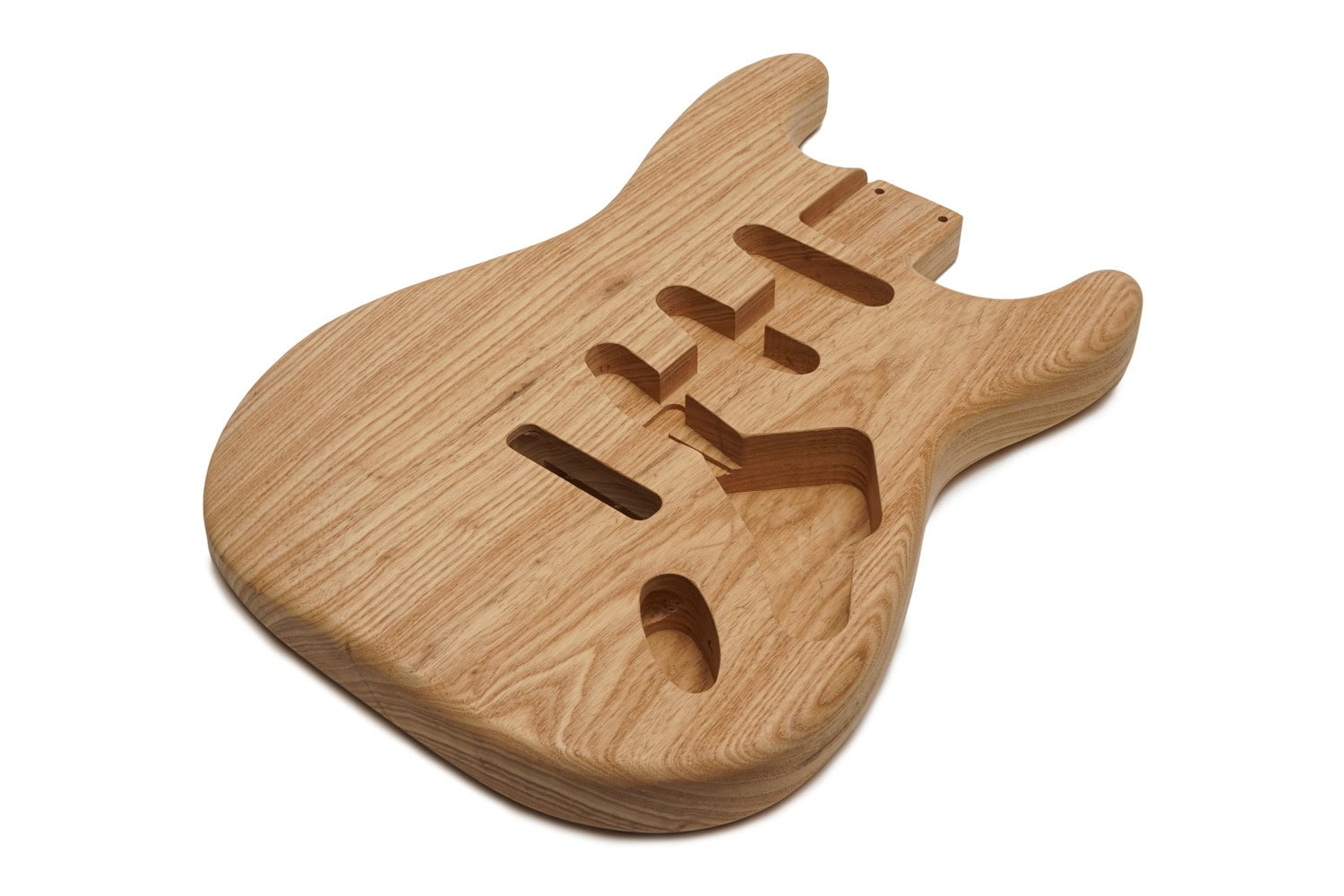 Natural unfinished wooden guitar body with routed cavities for pickups and controls shown on white background.