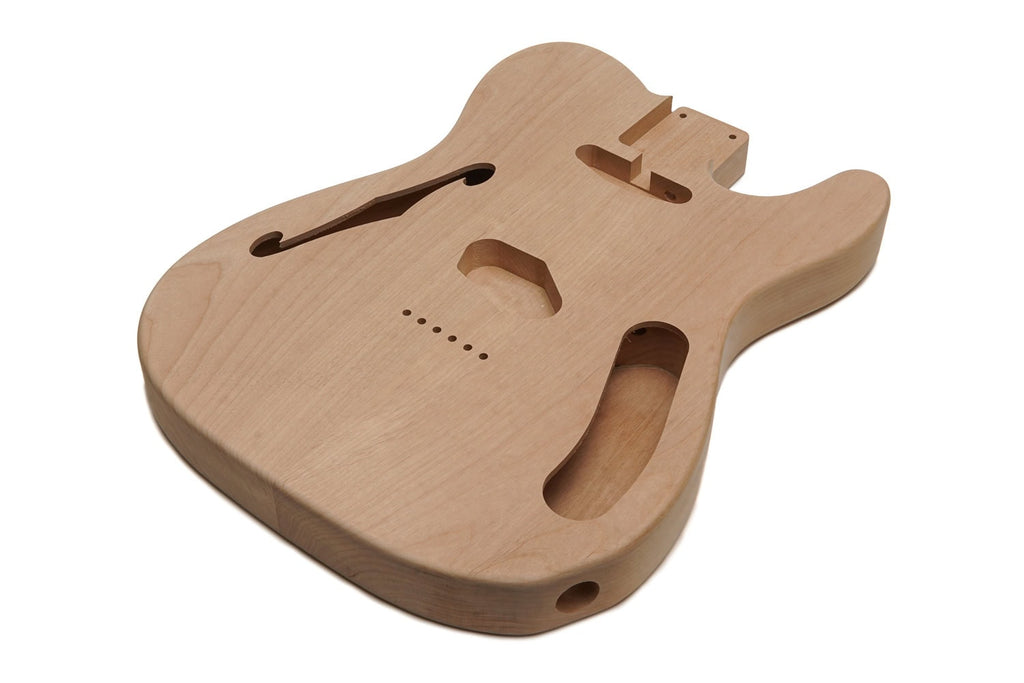 Unfinished natural wood thin guitar body with f-hole and cavities for pickups and controls.