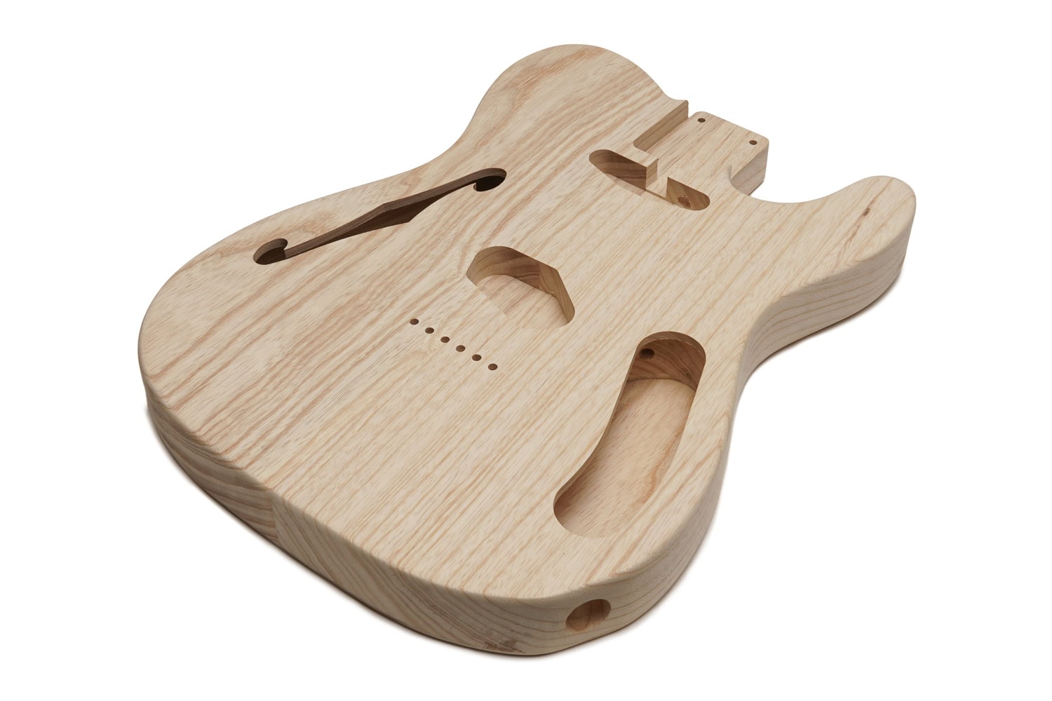 Unfinished light ash wood guitar body with distinctive cutouts and an f-hole on a white background.