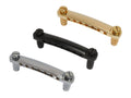 Three stop tailpieces with studs in gold, black, and silver colors arranged on a white background.