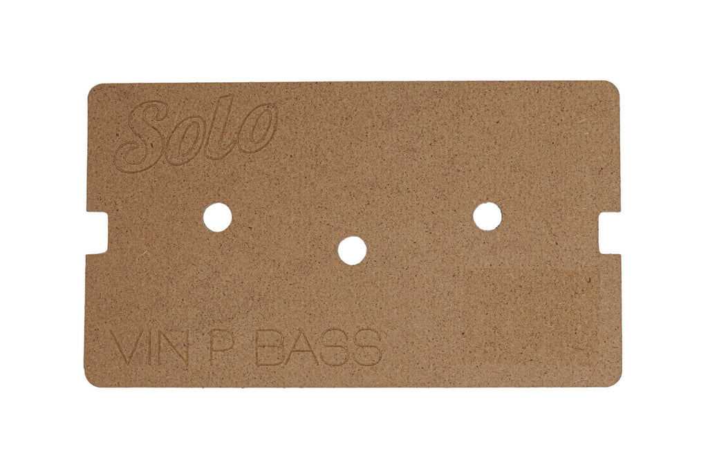 Rectangular brown wooden template with three circular holes and engraved text on it.