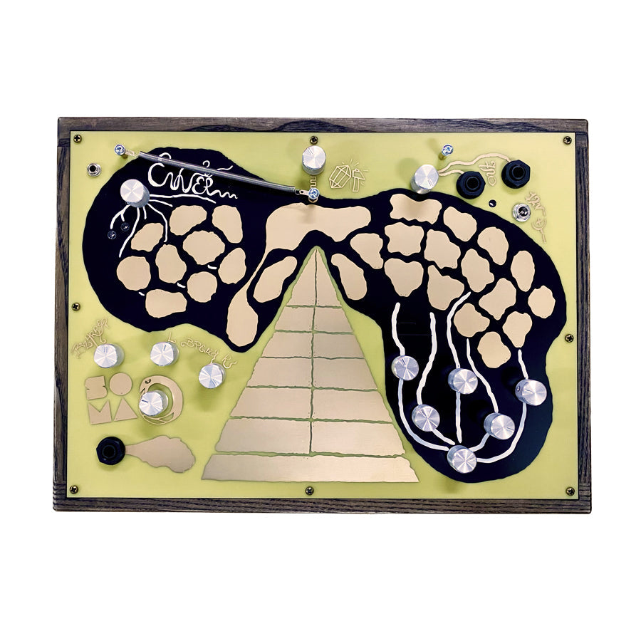 Top view of a wood-framed synthesizer with yellow faceplate, various silver knobs, switches, and 1/4 inch jacks.