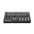 Black electronic device panel with multiple metal pegs, knobs, red switches, levers, and metal discs.