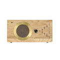 Rectangular light wood device with gold round speaker grille and a black rotary knob on the front panel.