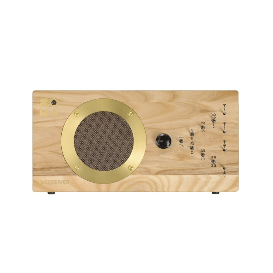 Rectangular light wood device with gold round speaker grille and a black rotary knob on the front panel.