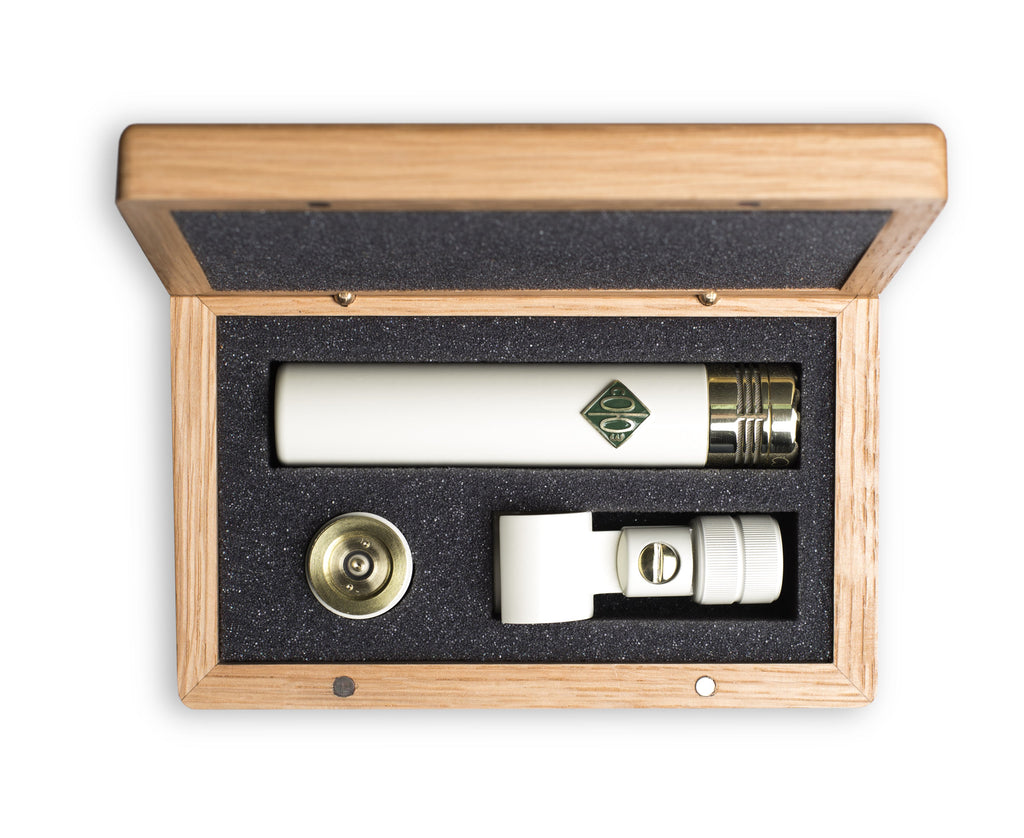 White cylindrical microphone with gold connector and accessories in a wooden box with foam insert.