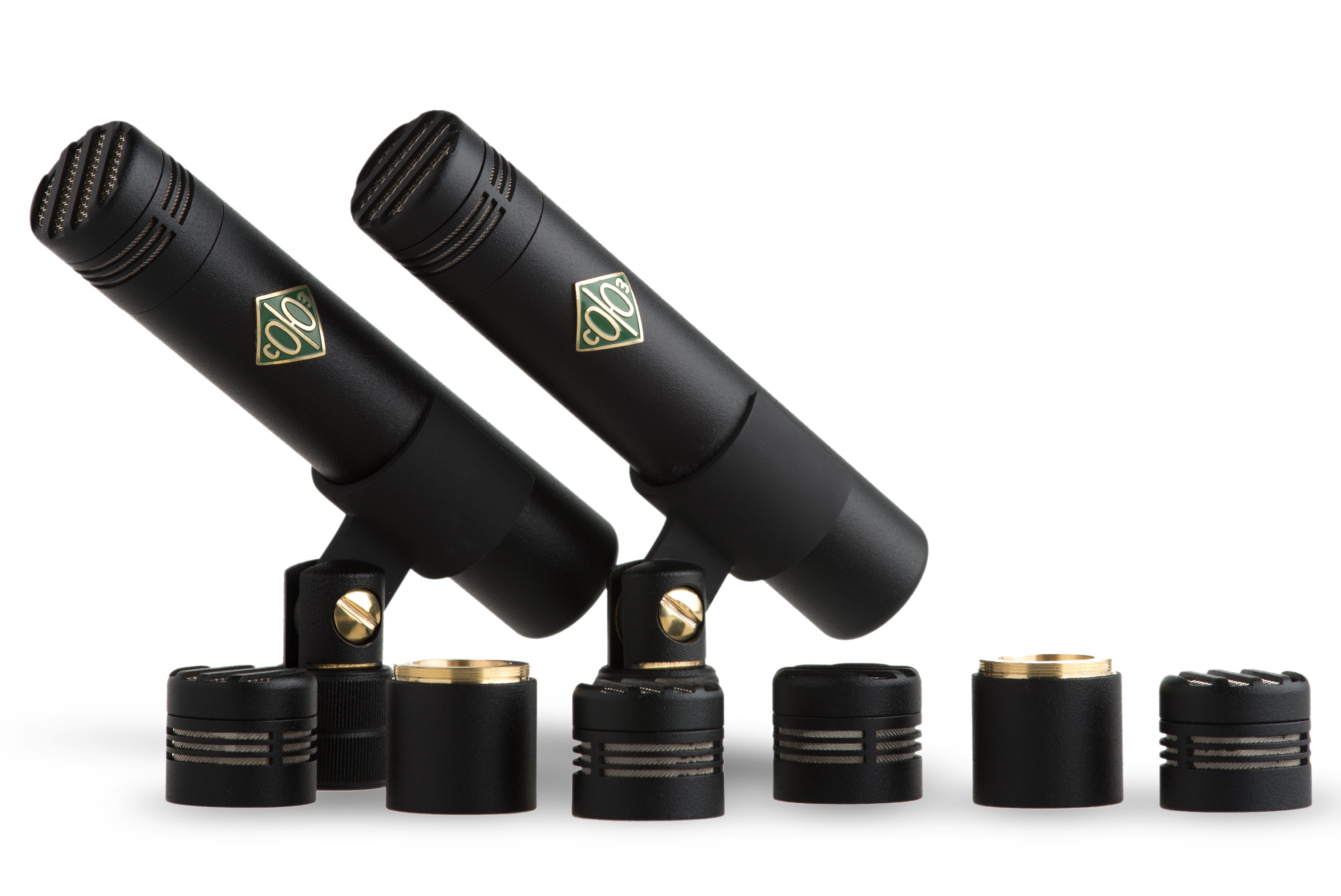 Two black microphones with mounts and six interchangeable capsules arranged in a row