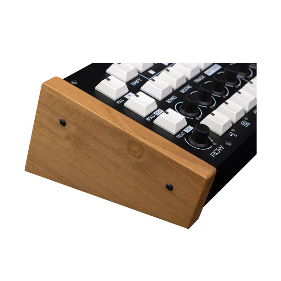 Black music sequencer panel with white buttons and black knobs with attached brown wooden end cheek.