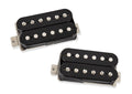 Two black humbucker pickups for electric guitar with metal mounting tabs on a white background.