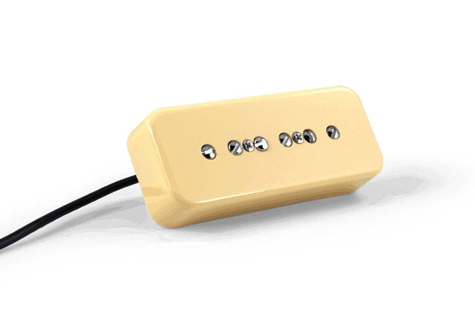 Cream-colored soapbar electric guitar pickup with exposed pole screws and attached black wire.