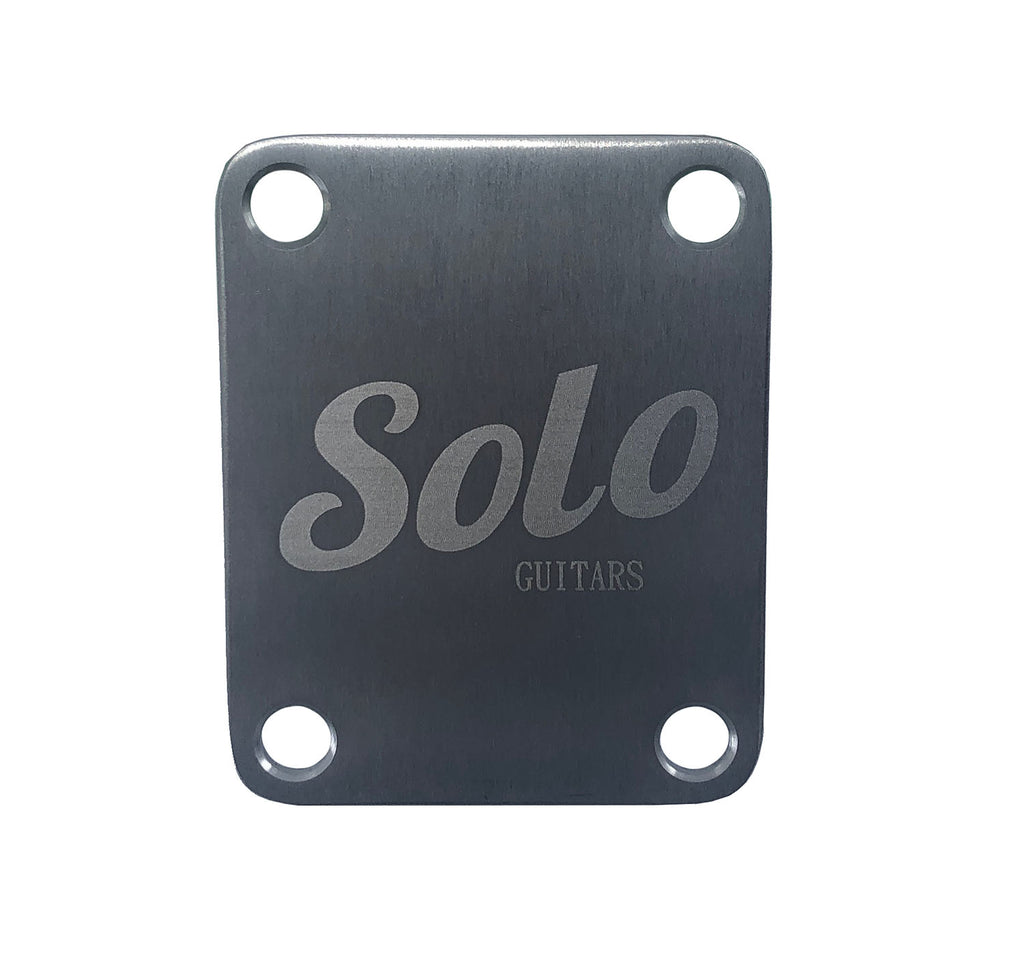 Silver rectangular metal plate with four bolt holes and engraved text reading Solo GUITARS.