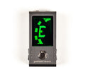Black compact pedal tuner with green digital display and single footswitch labeled Peterson.