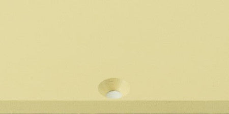Cream-colored single-ply plastic pickguard blank with a center mounting hole on a plain background.