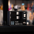 Black guitar pedal with two sliders, a toggle switch, a footswitch, and Tape Audio Co. branding.