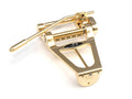 Gold-colored metal guitar tremolo unit with a tremolo arm and adjustment knob.
