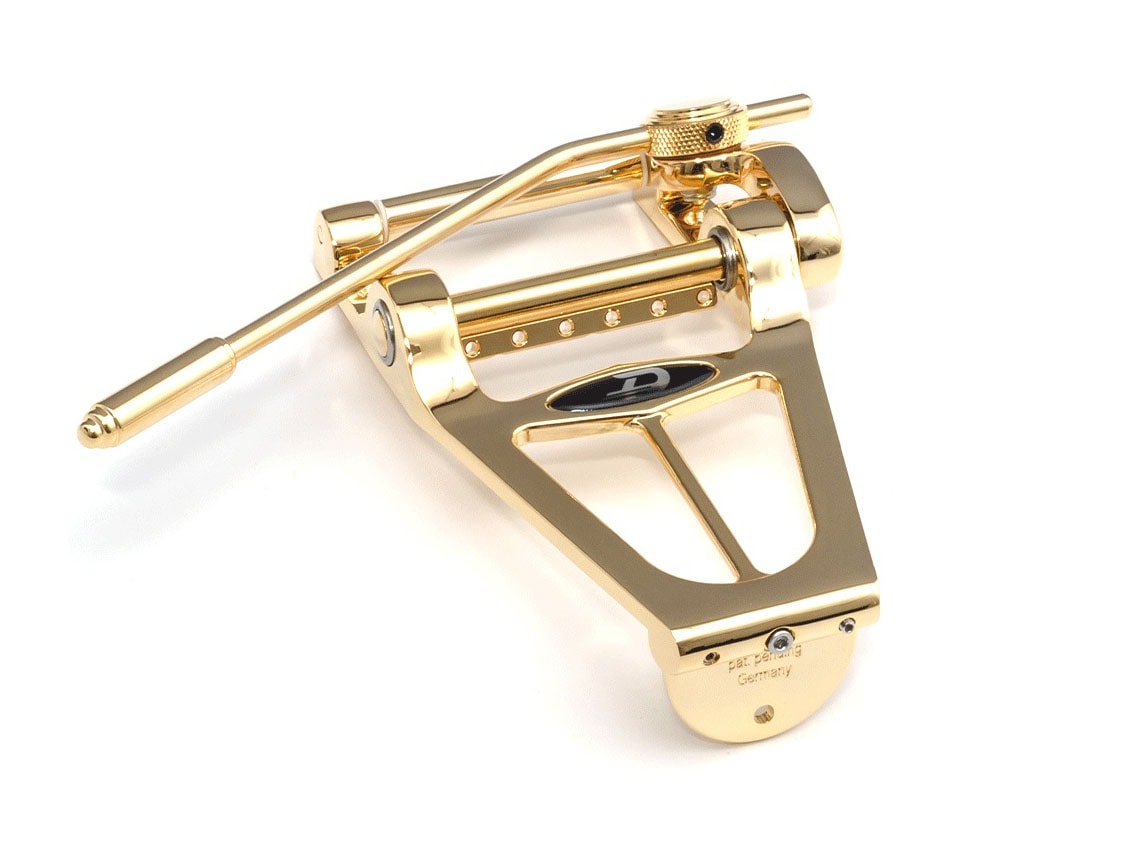 Gold-colored metal guitar tremolo unit with a tremolo arm and adjustment knob.