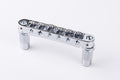 Chrome metal roller Tune-o-matic style bridge with adjustable saddles on white background.