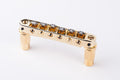 Gold metal roller Tune-o-matic bridge with six rollers and two knurled posts on white background.