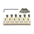 Six off-white guitar saddles with adjustment screws, six silver mounting screws, and one black hex wrench on a white background.