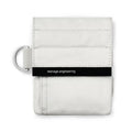 Small white fabric bag with black horizontal band labeled 'teenage engineering' and a metal ring on the side.