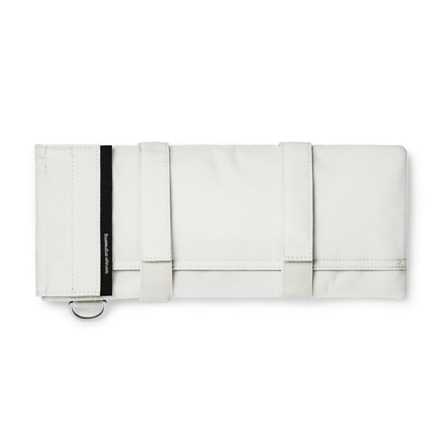 White fabric carrying case with two straps, black tag, and metal D-ring.