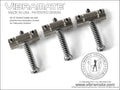 Three metal slotted saddles with dual screws for guitar intonation adjustment.