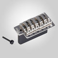 Silver metal guitar tremolo bridge with six saddles and one mounting screw on a light background.