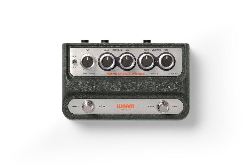 Top view of a dark green Warm Audio guitar pedal with knobs, switches, and two footswitches labeled Effect and Vibrato.