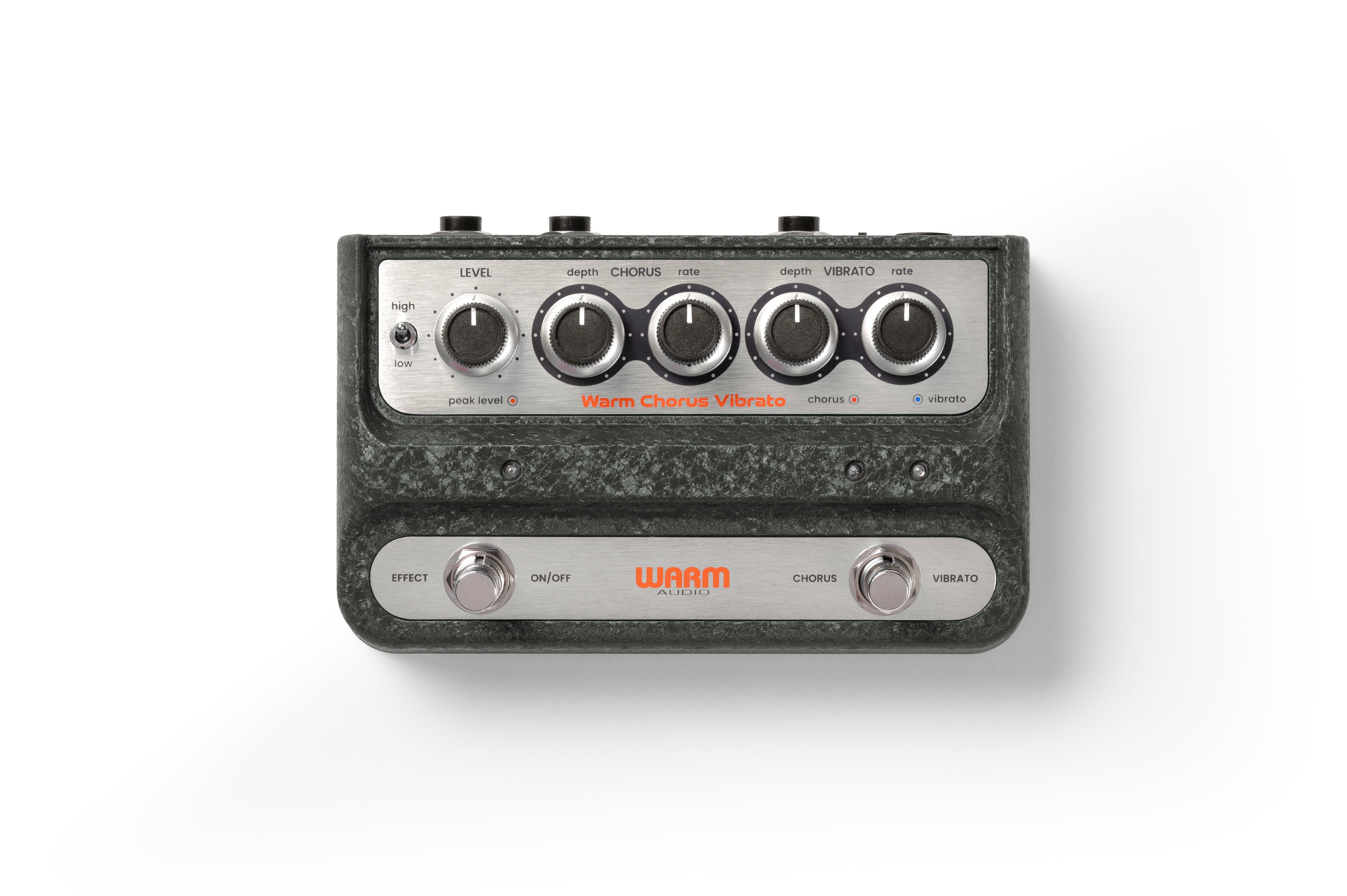 Top view of a dark green Warm Audio guitar pedal with knobs, switches, and two footswitches labeled Effect and Vibrato.