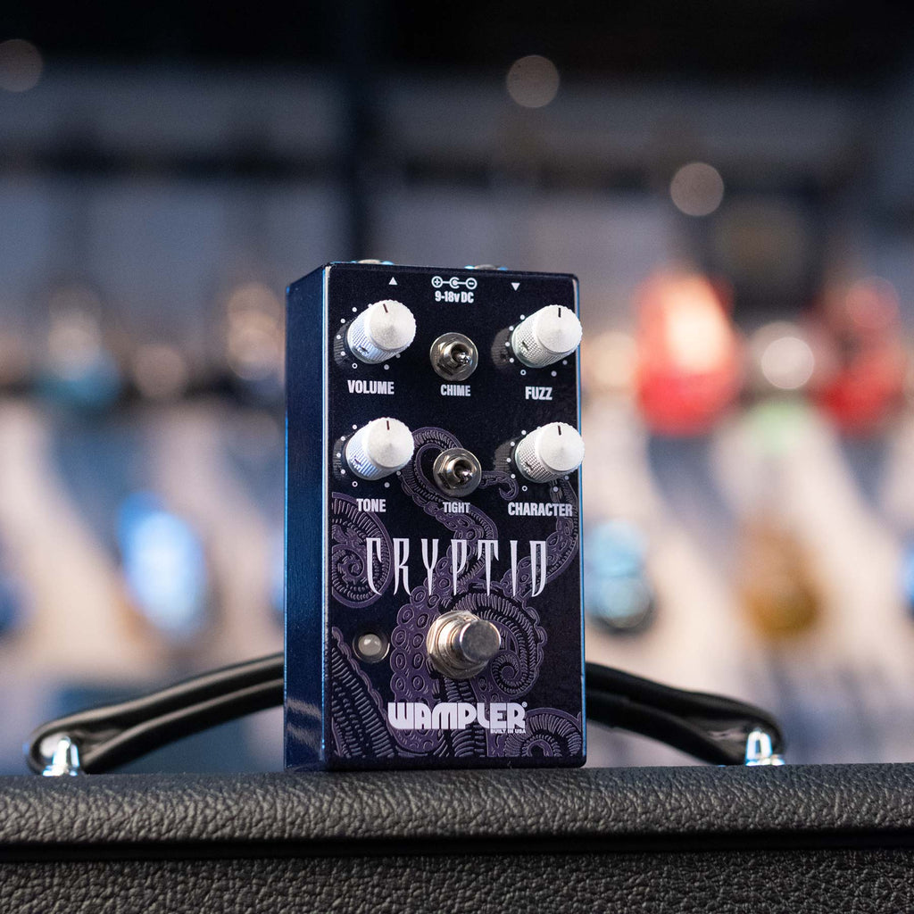 Black and blue guitar effects pedal with knobs, switches, and footswitch labeled Cryptid by Wampler.