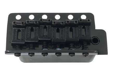 Black metal guitar bridge with six adjustable saddles and screws, labeled Wilkinson.