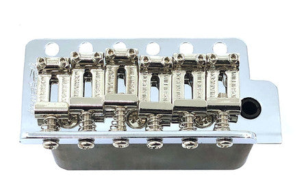 Chrome metal guitar tremolo bridge with six adjustable saddles on a white background.