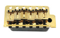 Gold-colored metal guitar bridge component with six string saddles and adjustment screws.