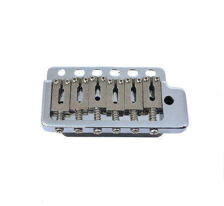 Chrome metal tremolo bridge with six adjustable saddles and mounting holes on a white background.