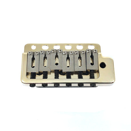 Gold-colored 6-saddle guitar tremolo bridge with six mounting holes on a white background.
