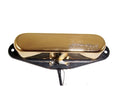 Gold-colored guitar pickup with black baseplate and attached wire leads visible from below.