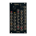 Black electronics module with multiple 3.5mm jack sockets, two knobs, and gold graphic lines and text.