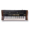 Top view of a Yamaha SK-20 keyboard synthesizer with wooden side panels and various sliders and buttons.