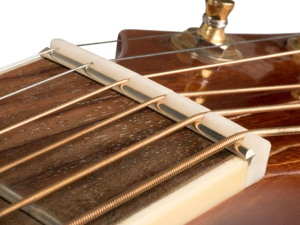 Close-up image of a guitar nut installed on a guitar neck with strings passing through its slots.