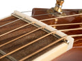 Close-up image of a guitar nut installed on a guitar neck with strings passing through its slots.