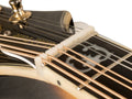 Close-up of a white slotted nut installed on a stringed instrument headstock with metal strings.