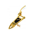 Gold-colored vibrato tailpiece with black plate and screws on a white background.