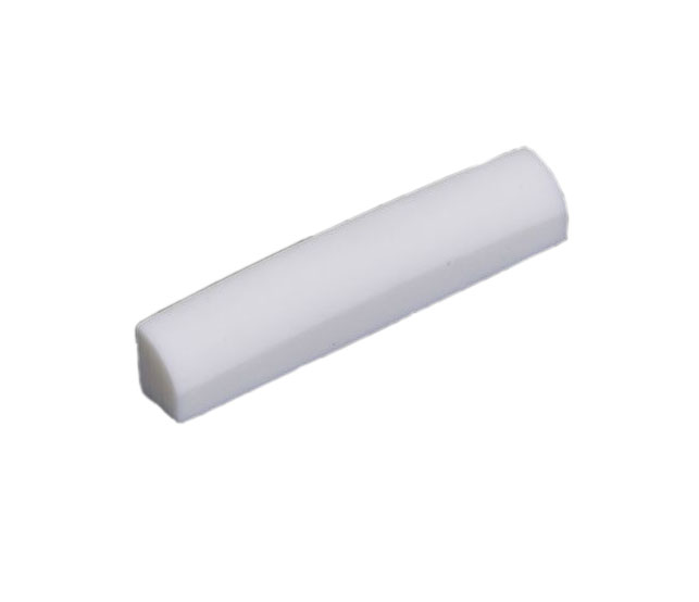 A white curved rectangular guitar nut with a flat bottom shown on a white background.