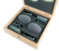 Two gray microphones with clips and windshields in a foam-lined wooden case with lid open.