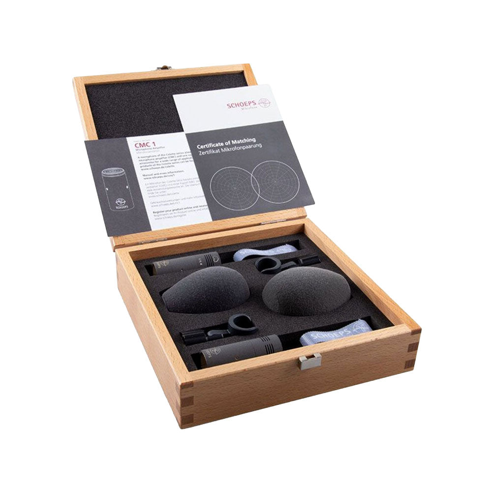 Open wooden box containing two microphones, foam windshields, clips, straps, and a certificate with instruction manual.