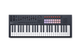 Black and white MIDI controller keyboard with keys, pads, knobs, faders, and a small screen