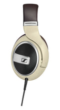 Beige and brown over-ear wired headphones with black mesh ear cup and visible SENNHEISER branding on headband.