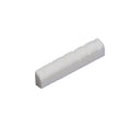 White slotted electric guitar nut shaped to fit a fretboard end.