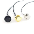 Three metal push button switches with attached black wires in black, gold, and silver colors.